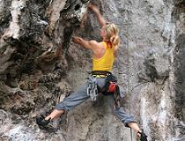 Een vrouwelijke rotsbeklimmer bij East Railay wall in Krabi. Ook kun je vanuit Krabi rotsklimmen op de kliffen die loodrecht uit het water omhoog rijzen. Een waanzinnig mooie ervaring: je hebt hier geen gewone heuvels en bergen onder je, maar een turquoise oceaan.